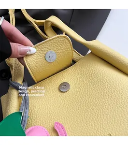 Detail of magnetic buckle closure on yellow lychee texture leather bucket handbag