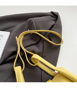 Detail of bright yellow lychee leather shoulder strap with silver metal buckle