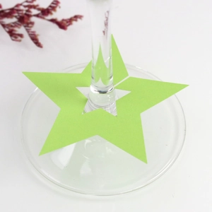 Detalle de tarjeta de mesa con forma de estrella verde para copa de vino y decoración de fiesta