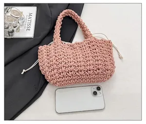 Mini-Strickhandtasche in Rosa mit Kordelzug-Innentasche neben einem Smartphone gezeigt