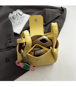 Internal view of yellow pebbled leather bucket bag showing compartments and elephant charm