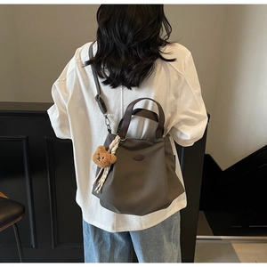 Détail du grand sac cabas en toile avec logo en cuir et charmant ours en peluche