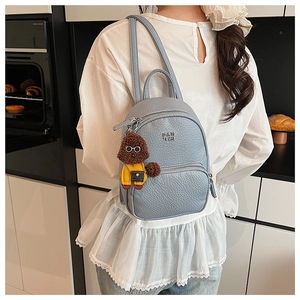 Détail d'un mini sac à dos bleu clair en similicuir avec un charmant petit ours