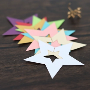 Vista macro de tarjetas de mesa coloridas en forma de estrella sobre fondo de madera oscura