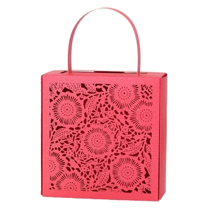 Detail of red laser-cut candy box featuring intricate floral hollow patterns and handle