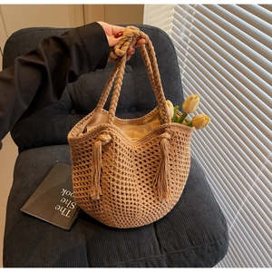 Détail d'un sac cabas en paille tissé à la main avec de longues franges et anses en corde