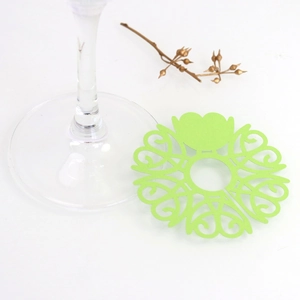 Detail of laser-cut heart pattern paper wine glass place cards in bright green
