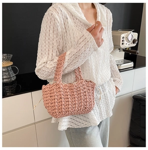 Detail of pink hand-woven mini bucket bag with drawstring liner and thick knit texture