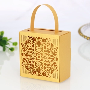 Macro shot of matte gold wedding favor box with intricate laser-cut lace pattern detail