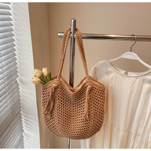 Détail du sac à bandoulière en paille tressé à la main avec glands et doublure