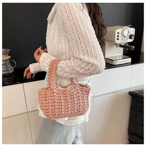 Detail of hand-woven dusty pink bucket bag with cream drawstring liner and thick knit texture