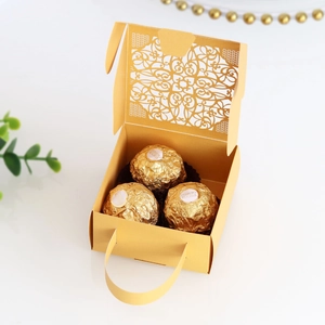 Macro detail of laser-cut hollow lace pattern on matte gold wedding candy gift box