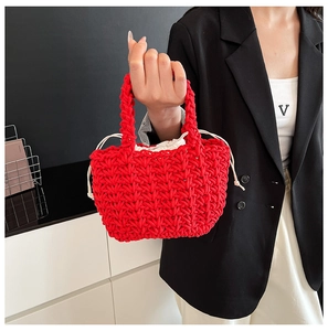 Close-up of vibrant red woven tote bag featuring a cream drawstring inner pouch
