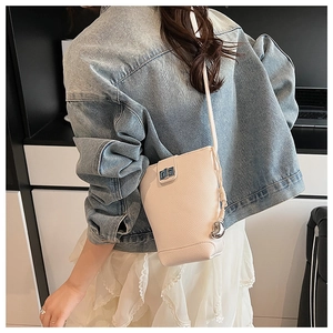 Detail of white lychee leather bucket bag with silver twist lock and metal ball strap accent