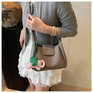 Detail view of leather texture with button closure and cute elephant pendant