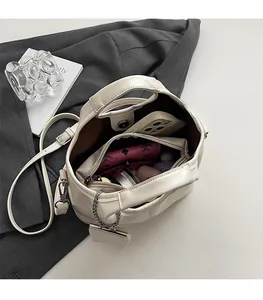 Top view of cream bucket bag interior showing spacious main compartment and zip pocket