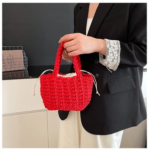 Detail of red hand-woven bucket bag with white drawstring liner on a black blazer outfit