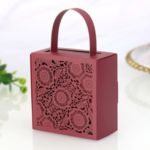 Detail of laser-cut floral hollow pattern on burgundy gift box with handle