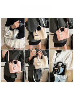 Multiple styles of shiny leather shoulder bags shown with matching mini pouches on a model