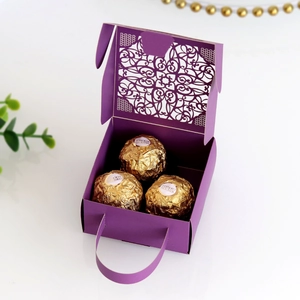Macro detail of laser-cut lace pattern on purple wedding candy gift box with handle