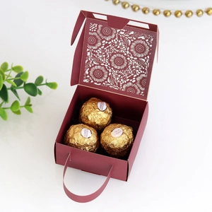 Macro view of burgundy laser-cut sunflower candy box with integrated handle and chocolate