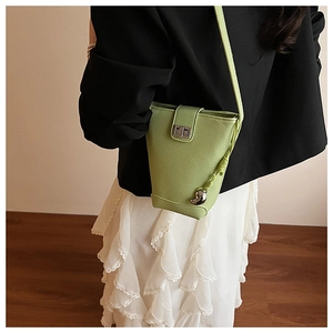 Detail of light green pebbled leather bucket bag with silver twist lock and knot detail