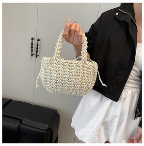 Close-up of cream hand-woven bucket bag featuring thick rope texture and drawstring liner