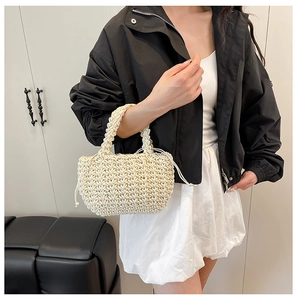 Detail showing the cream woven texture and drawstring inner pouch of this stylish bucket bag