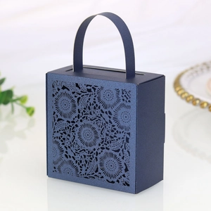 Detail of laser-cut floral pattern on navy blue wedding favor box with pearl finish
