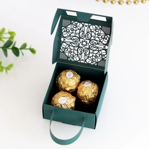 Detail of dark green laser-cut lace candy box with handle and floral patterns