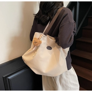 Détail du grand sac cabas en toile blanc cassé avec bandoulière et porte-clé ours