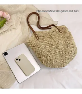 Detail view of woven straw tote with leather straps, showing iPad and phone size comparison