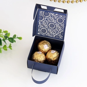 Detail of laser-cut navy blue wedding candy box with elegant hollow floral pattern