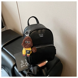 Détail du mini sac à dos noir en cuir grainé avec logo argenté et charmant chiot