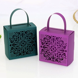 Macro view of laser-cut mandala lace patterns on purple and green favor boxes