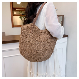 Detail of V-shaped woven texture and reinforced stitching on a brown straw tote bag