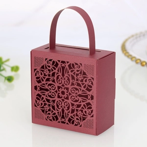 Detailed close-up of laser-cut lace patterns on burgundy wedding gift candy box with handle