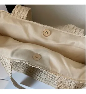 Détail du fermoir magnétique doré clair et de la doublure intérieure du sac cabas en paille
