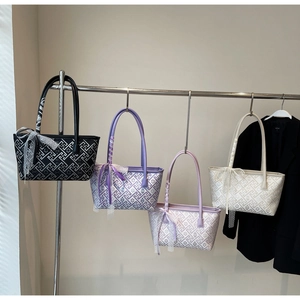 Detail showing four stylish tote bags in black, purple, and cream with geometric patterns