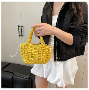 Detail of hand-woven bright yellow bucket bag with white drawstring closure and V-shaped texture