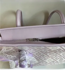 Detailed close-up showing the smooth metal zipper closure of the purple handbag