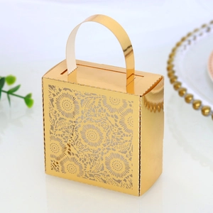 Detailed laser-cut mandala lace pattern on gold metallic candy box with top handle