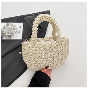 Dettaglio della borsa a secchiello intrecciata a mano color crema con fodera a coulisse