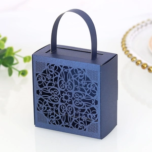 Detail of laser-cut lace pattern on navy blue wedding favor box with handle