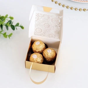 Detailed laser-cut floral pattern on gold gift box with elegant handle for weddings