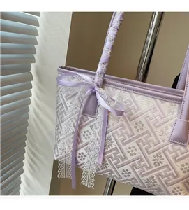 Close-up of lavender tote bag with white floral embroidery and silk ribbon handle decoration