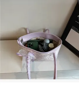 Close-up of lilac woven bucket bag with lace bow handle and large internal capacity