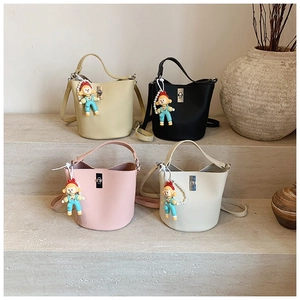 Close-up of litchi grain bucket bags in beige and pink with pearl cartoon charms