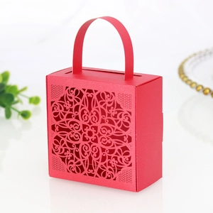 Macro detail of red laser-cut lace pattern on wedding favor box with handle