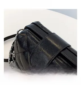 Close-up of classic black quilted leather bag with silver hardware clasp and chain strap